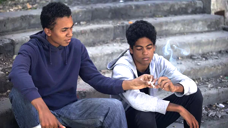 Two young Black men smoking marijuana