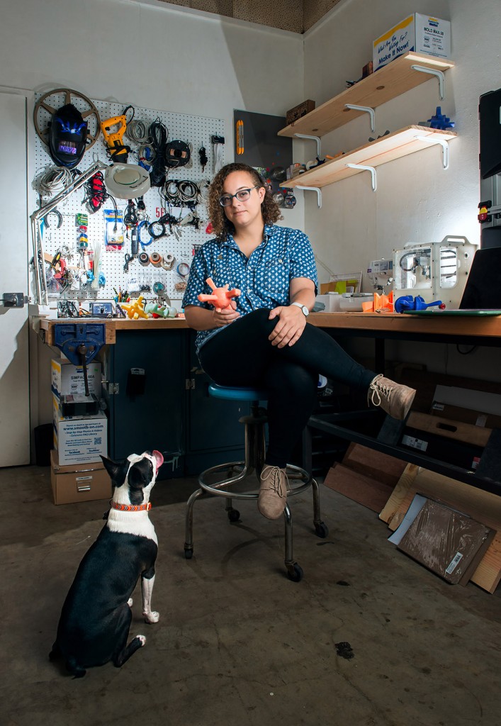 alt=Brittany Ransom plays with her dog, Bacon, inside her studio."