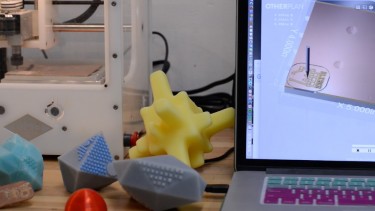 3D printed dog toys in front of a 3D printer.