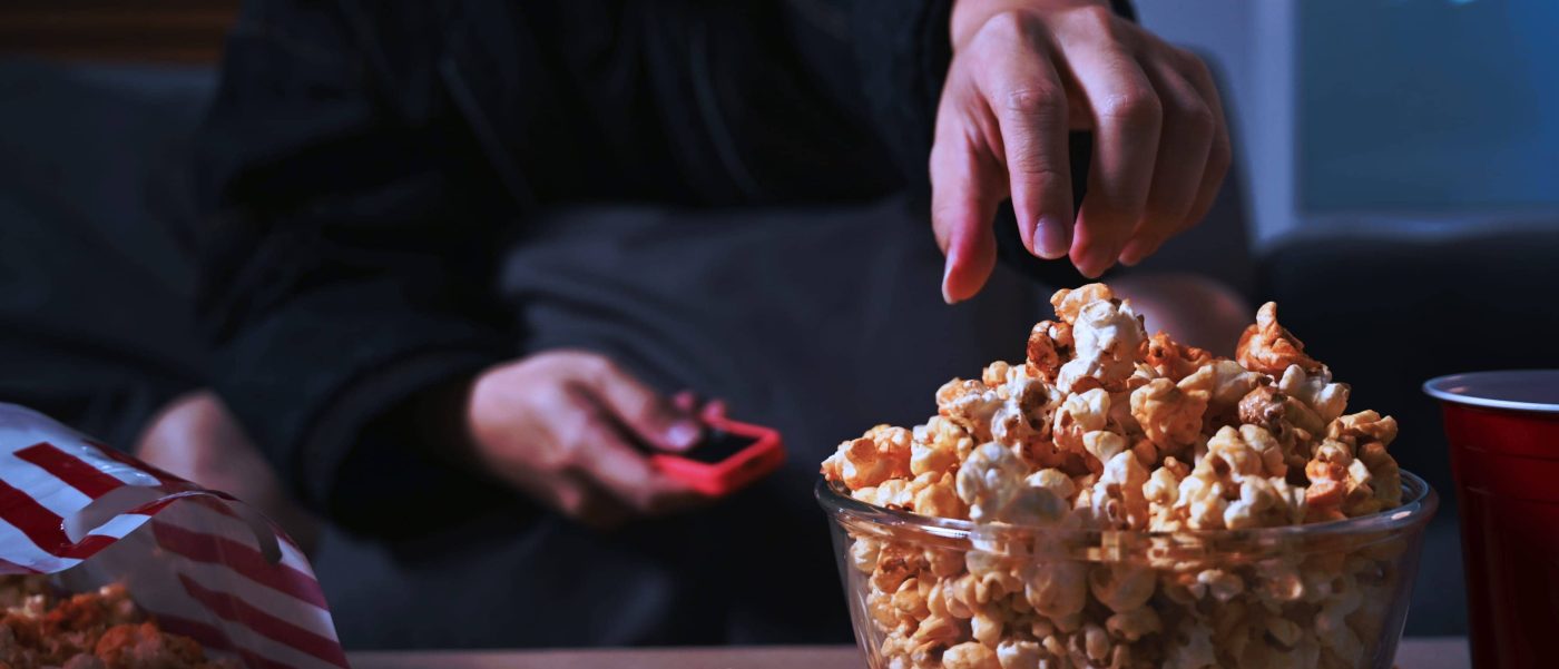 Persons hand above a bowl of popcorn