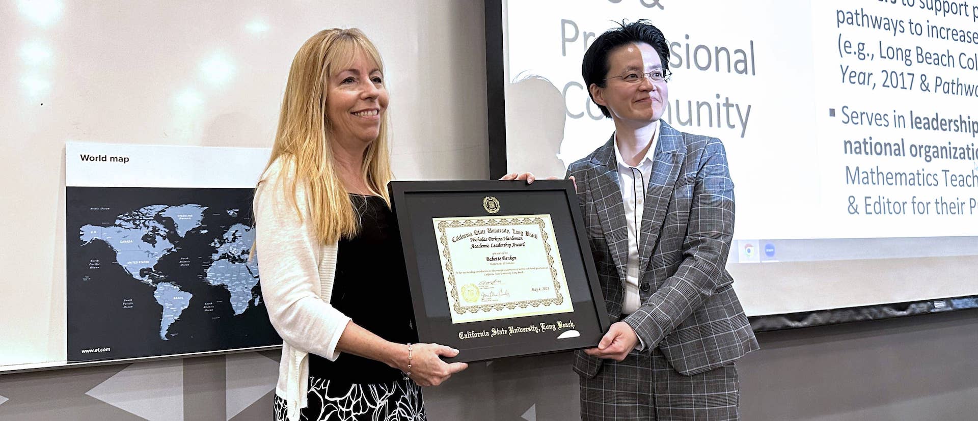 Two people holding an award certificate