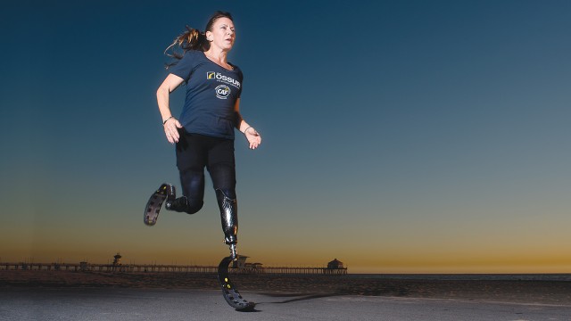 Paralympian and alumna Jami Goldman Marseilles runs on the beach with her prosthetic running legs.