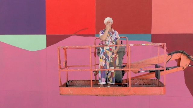 C Finley stands in front of her mural.