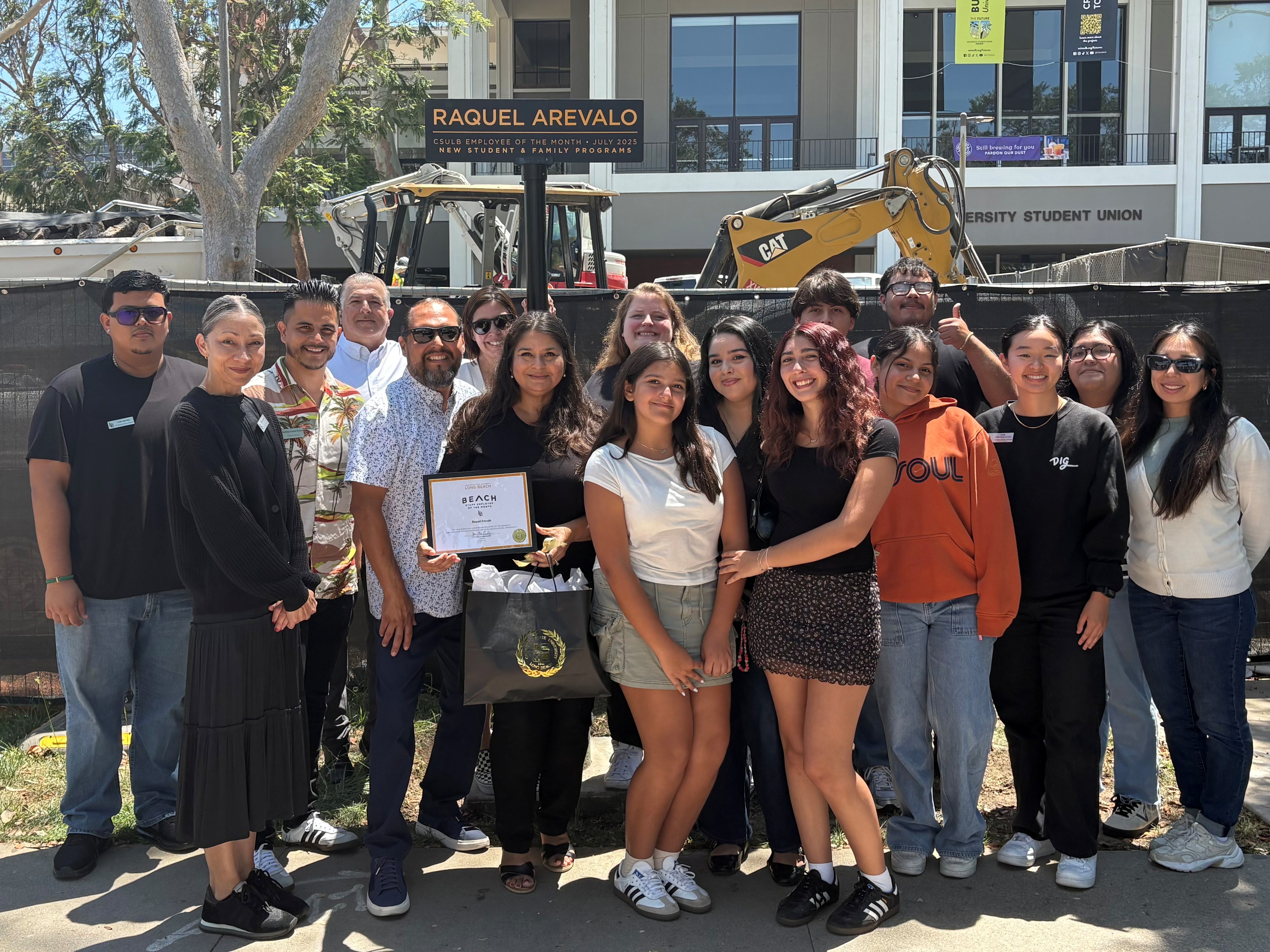 Raquel Arevalo with friends and coworkers ETOM signpost on Friendship Walk
