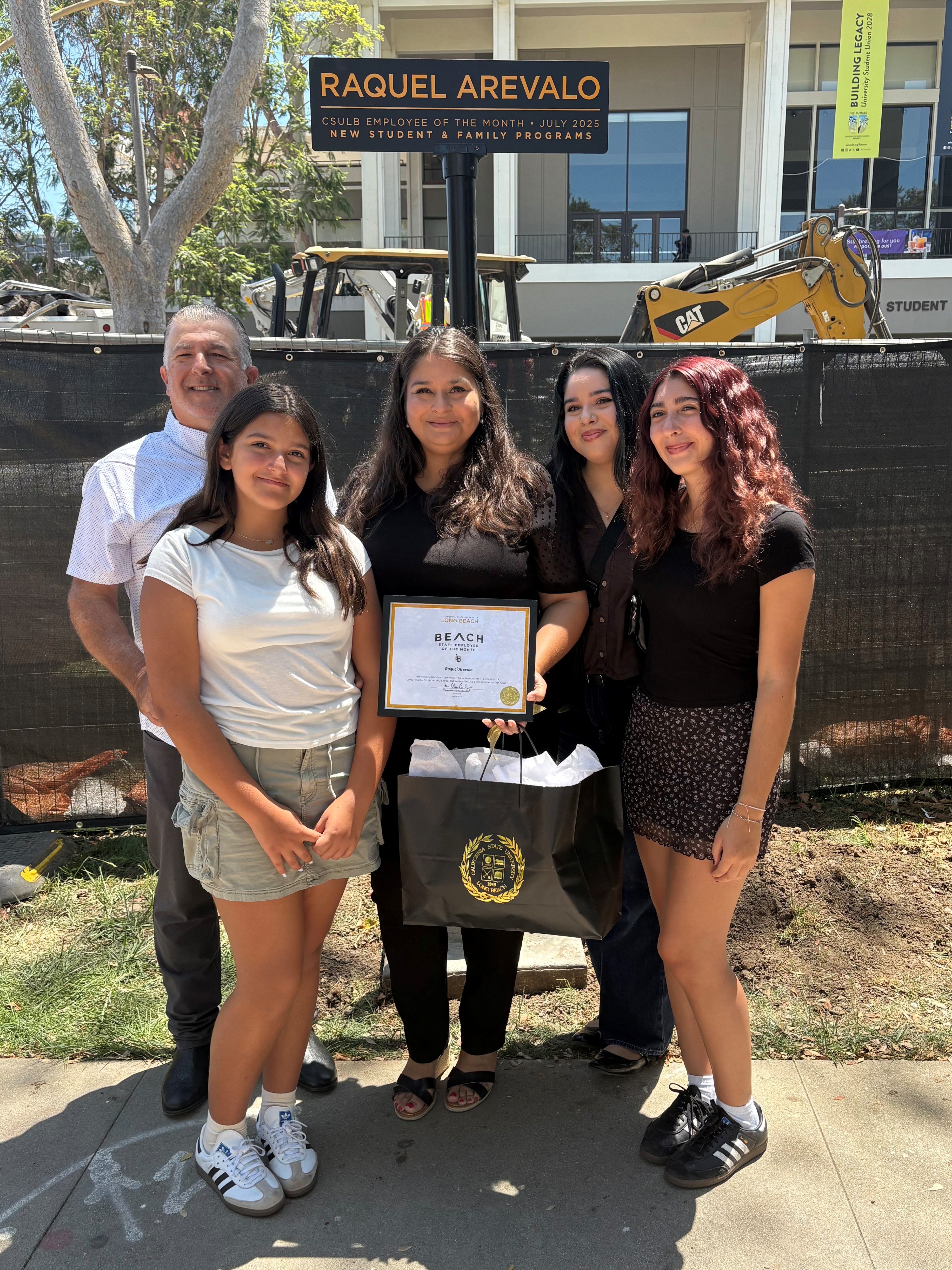 Raquel Arevalo with friends and coworkers ETOM signpost on Friendship Walk